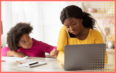 Mom on the computer and phone with child at the table