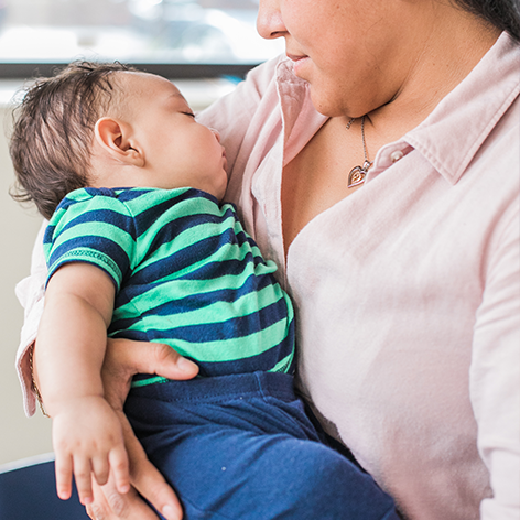 Baby with arms loose by his side.