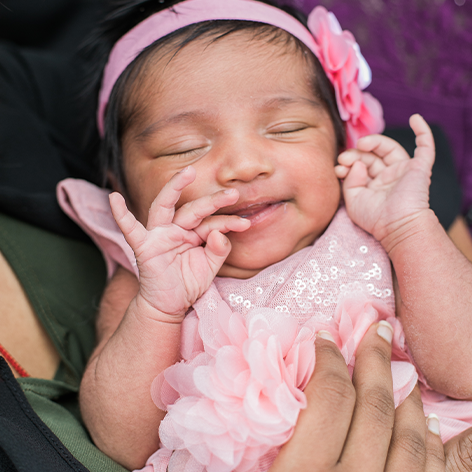 Baby with hands by her mouth.